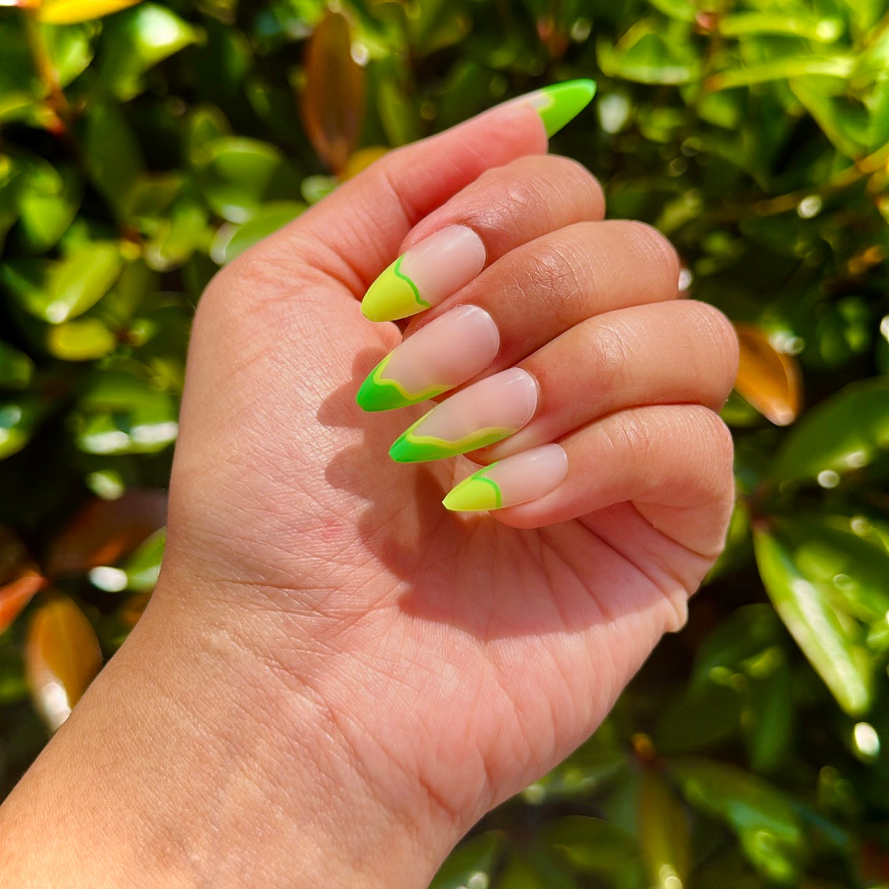 medium almond long lasting press on nails with a twisty evergreen and lime french tip and semi transparent nude base